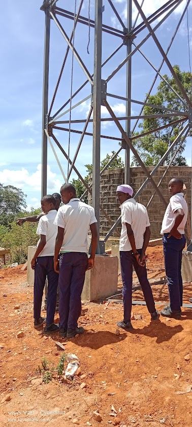 Physics students learning ties and girders at the borehole pylon